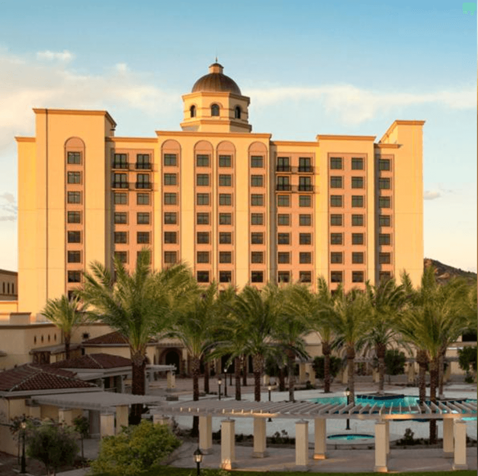 Casino Del Sol Resort tower with palm courtyard at golden hour.