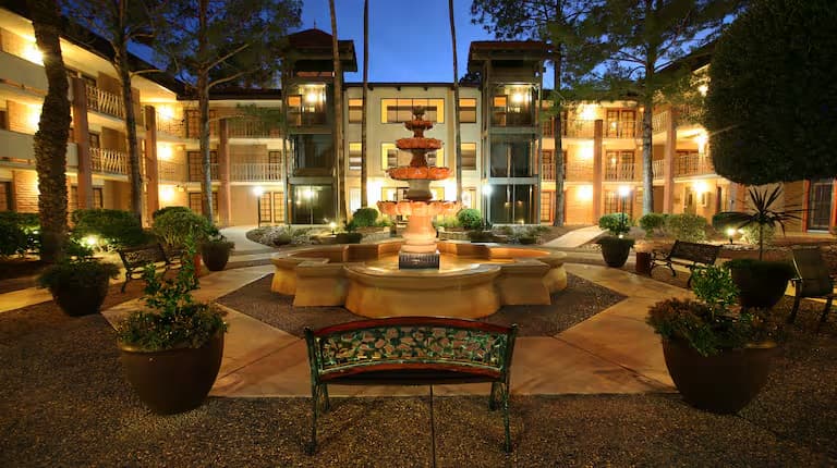 DoubleTree Suites courtyard fountain illuminated at dusk.